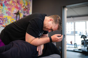 Sebastian Kaul vom x-thletik Team führt eine gezielte Rückenmassage bei einem Klienten durch – ein Beispiel für die therapeutische Behandlung bei Hexenschuss und Bandscheibenvorfall.
